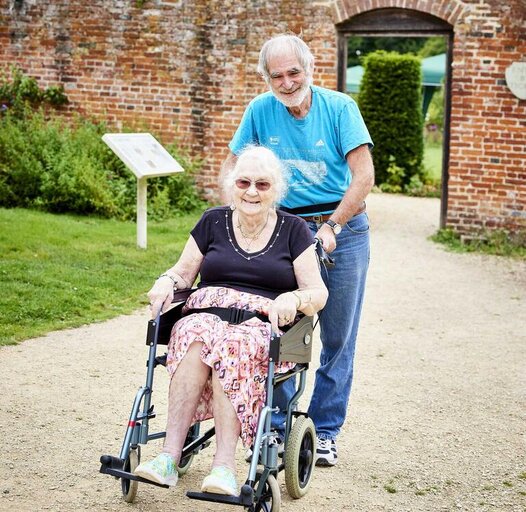 a man pushing woman in wheelchair