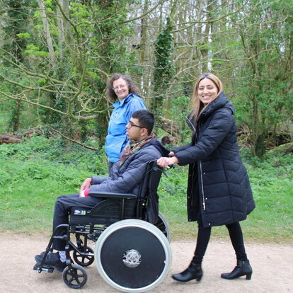 woman walking with her son in a wheelchair